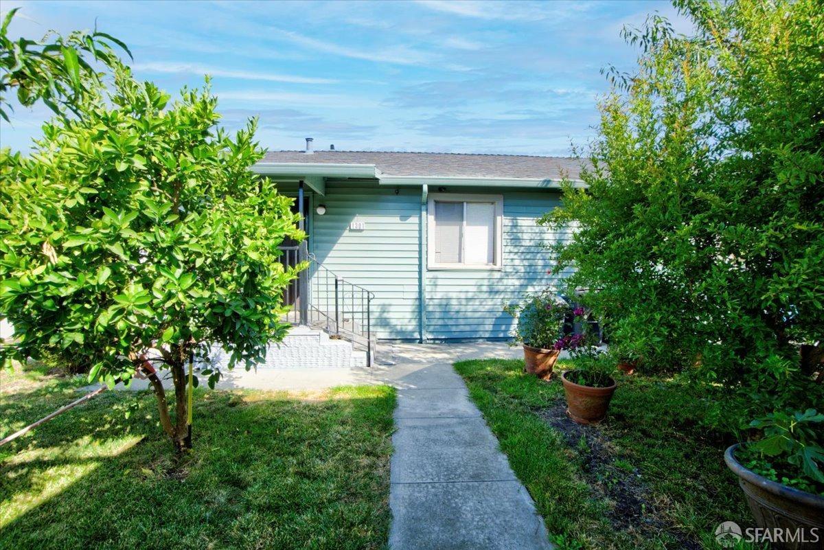 1309 80th Avenue Oakland, CA 94621 - Photo 55 of 75 a front view of a house with a yard and potted plants
