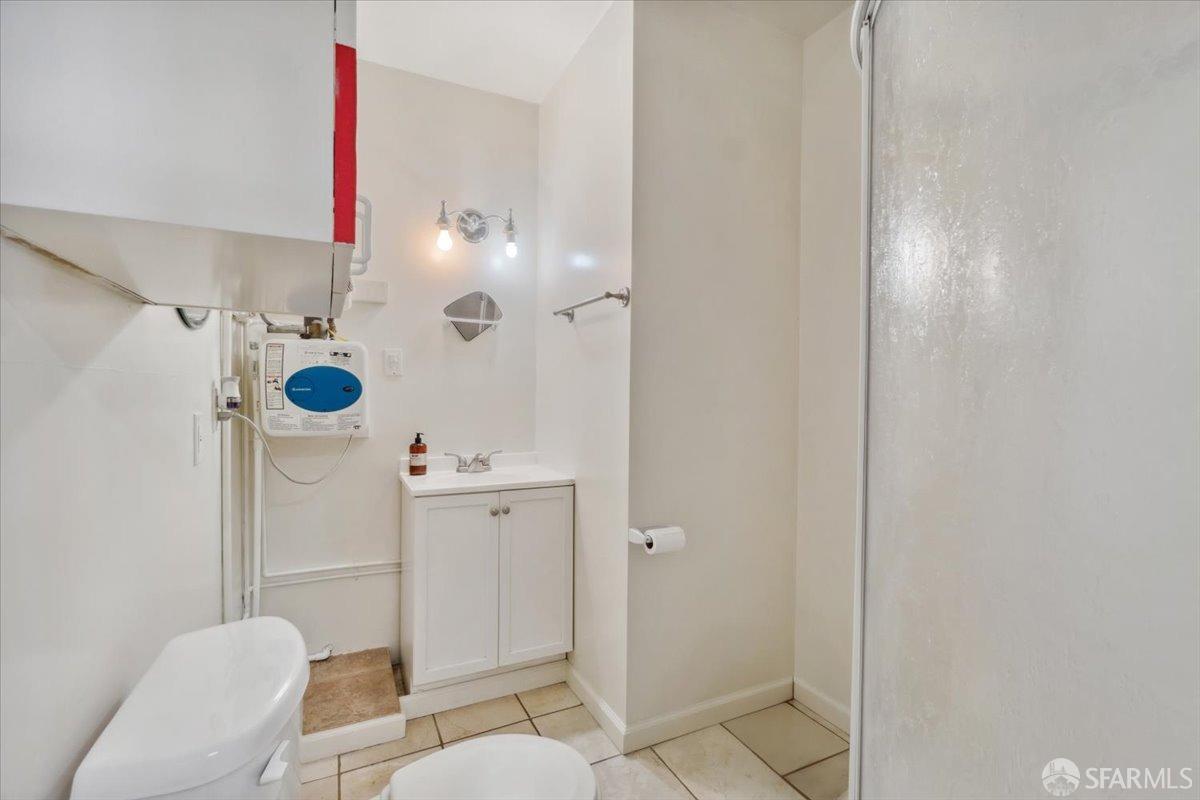 1309 80th Avenue Oakland, CA 94621 - Photo 74 of 75 a bathroom with a sink mirror vanity and toilet
