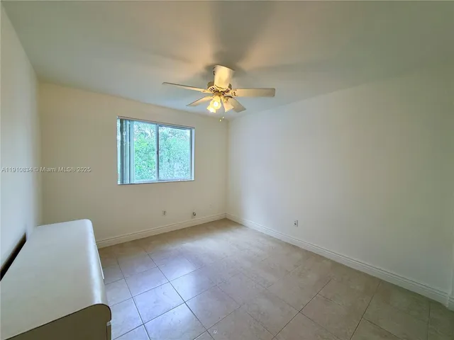 a view of a livingroom with a ceiling fan and window