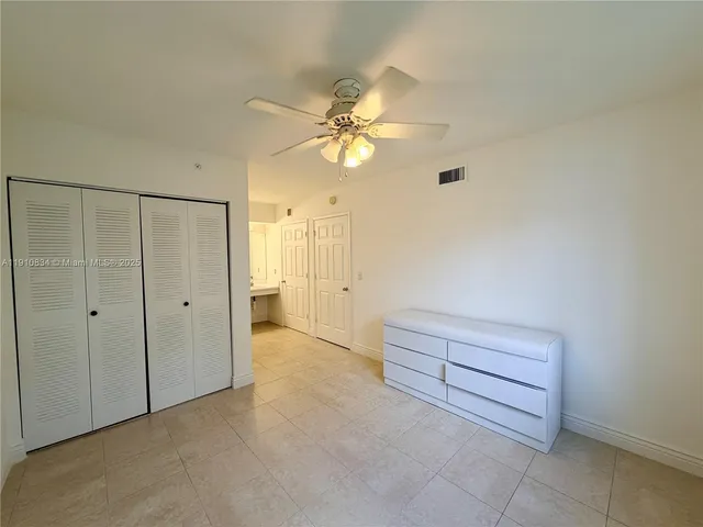 a view of a room with a stylish ceiling fan and entryway