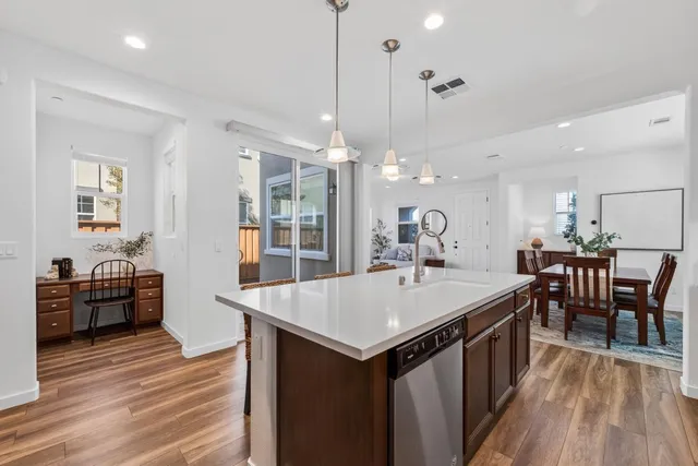 a large kitchen with kitchen island a sink and a wooden floor