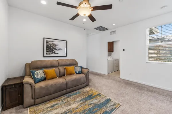a living room with furniture and a ceiling fan
