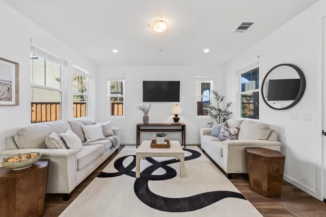 a living room with furniture a flat screen tv and a large window