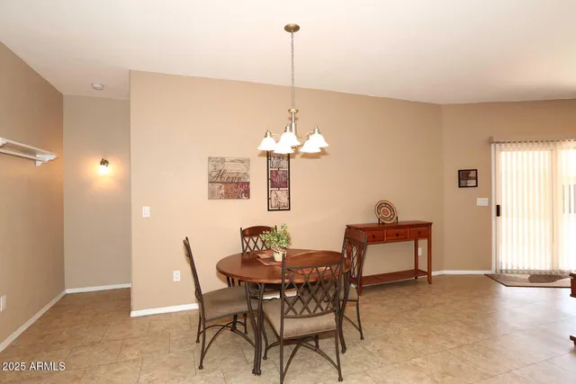 a dining room with furniture a chandelier and a window
