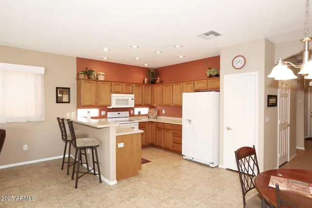 a kitchen with a refrigerator and table chair