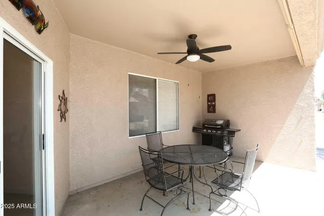 a dining room with furniture and a chandelier fan