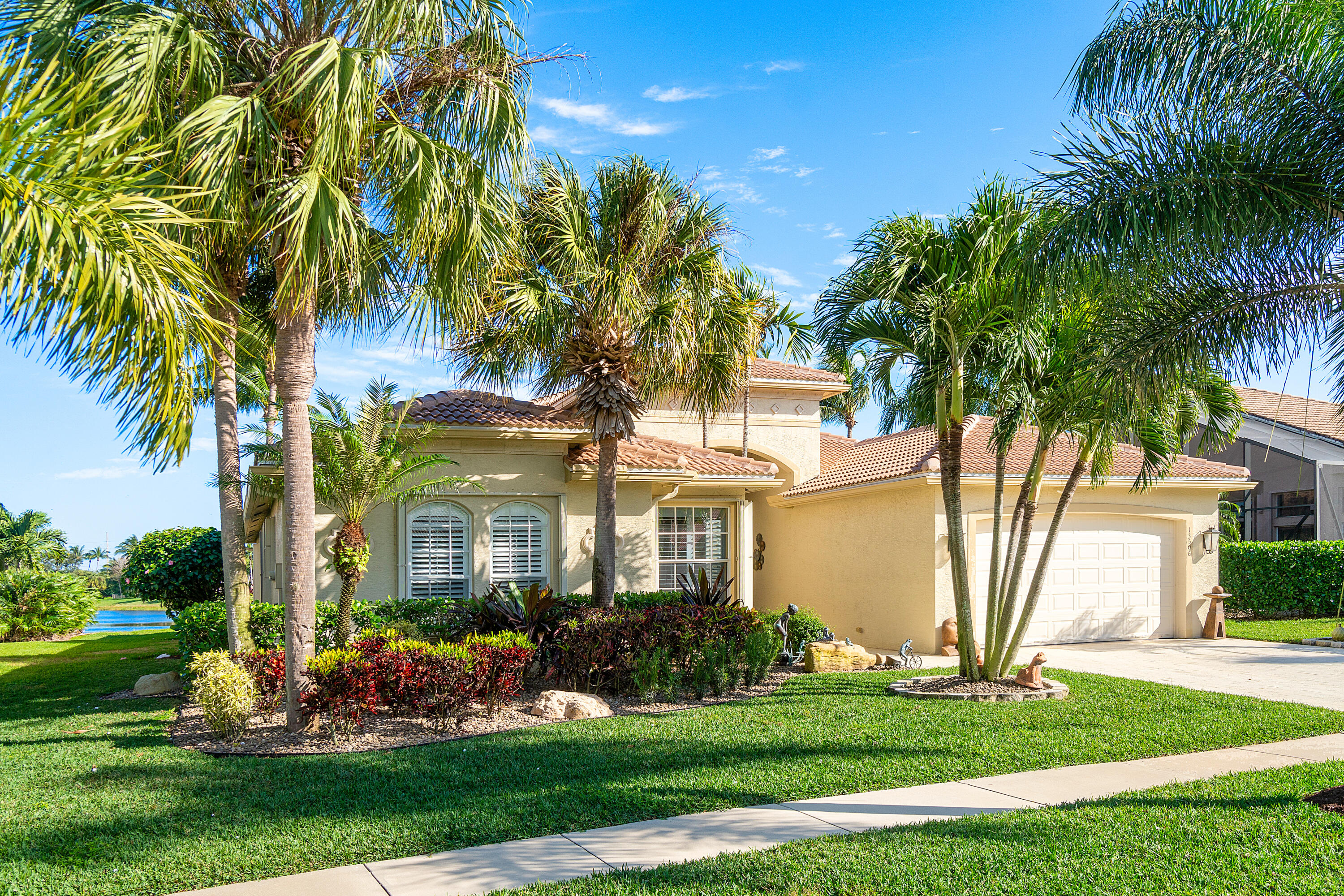 13506 Shell Beach Court Delray Beach, FL 33446 - Photo 3 of 66 a front view of a house with a garden and trees