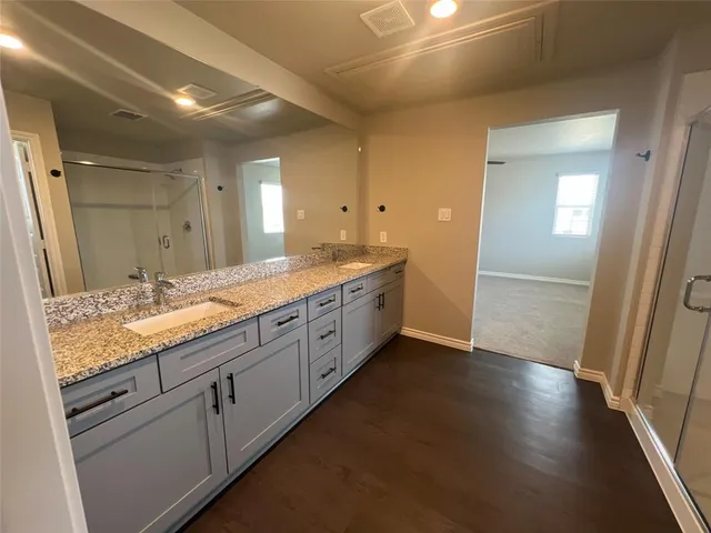 a spacious bathroom with a granite countertop sink and a mirror