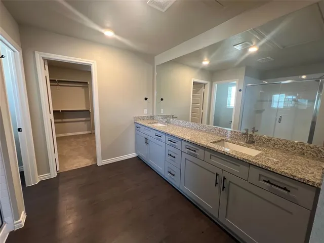 a bathroom with a granite countertop sink and a mirror
