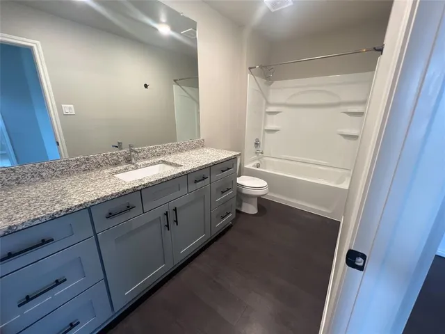 a bathroom with a granite countertop sink toilet and shower