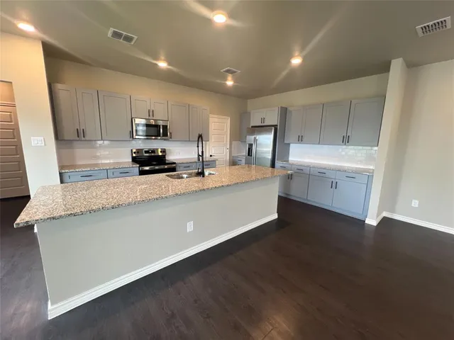 a view of a kitchen with a sink cabinets and wooden floor