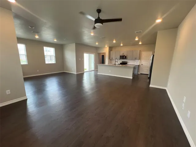 an open kitchen view with wooden floor a sink and a refrigerator