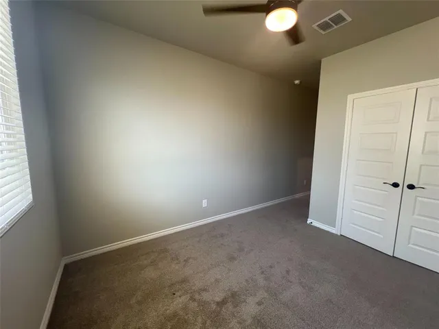 an empty room with closet and windows
