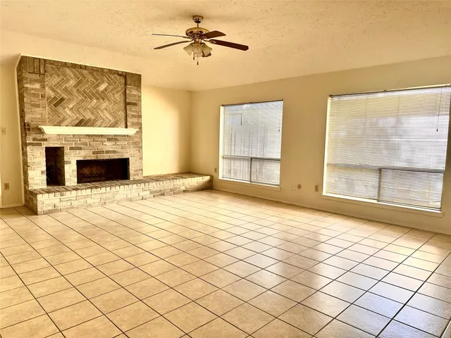 a view of empty room with wooden floor and fireplace