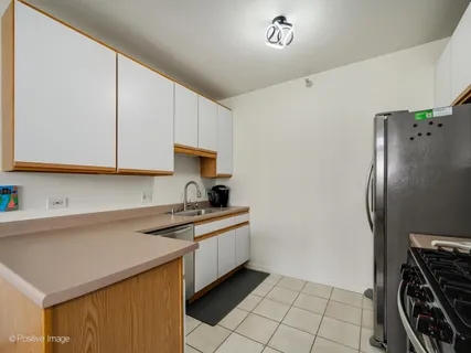 a kitchen with stainless steel appliances a sink a stove a refrigerator and cabinets