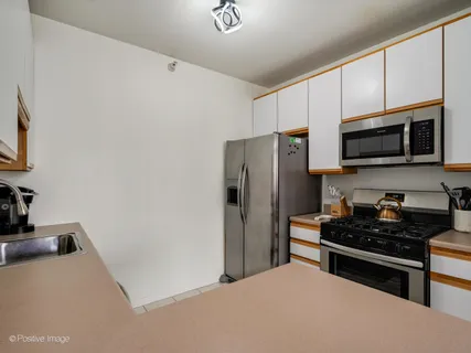 a kitchen with stainless steel appliances a refrigerator a stove a microwave and cabinets
