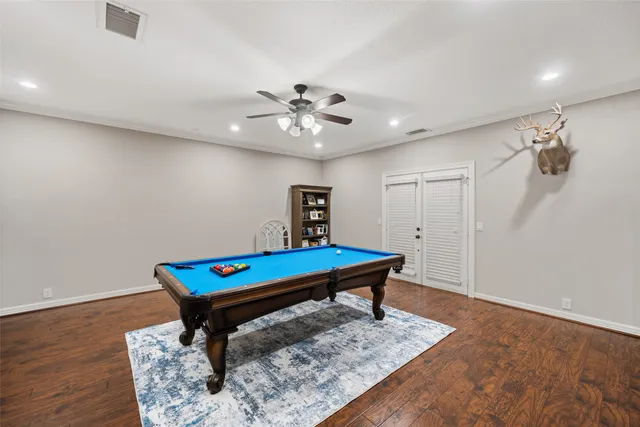 a room with pool table and wooden floor