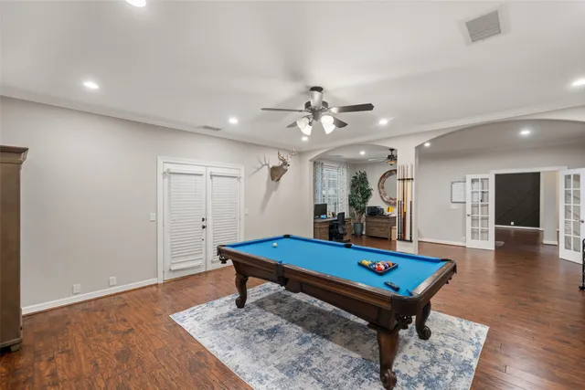 a room with pool table and wooden floor