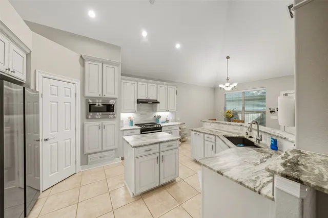 a kitchen with white cabinets and appliances