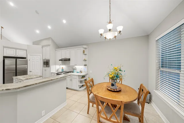 a view of a dining room with furniture a chandelier and wooden floor