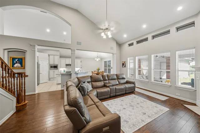 a living room with furniture kitchen and a wooden floor
