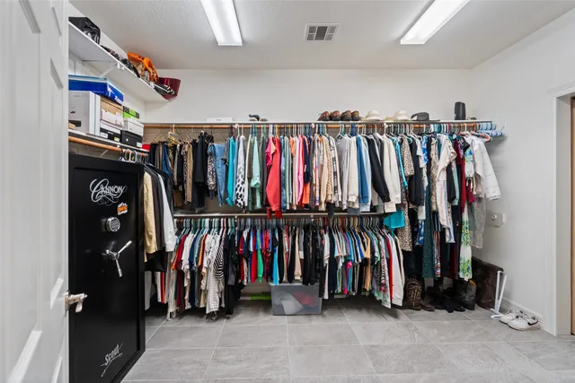 a view of walk in closet with clothes