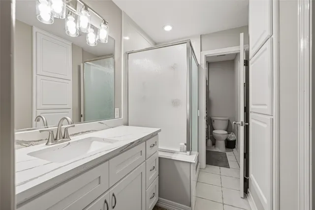 a bathroom with a shower sink vanity and mirror