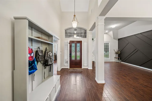 a view of a hallway with wooden floor and stairs