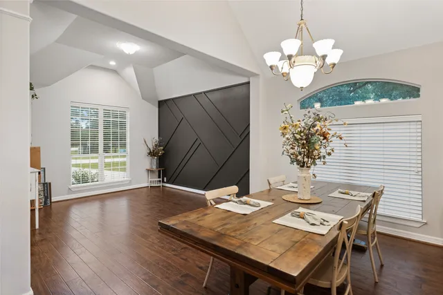 a view of a dining room with furniture wooden floor and chandelier