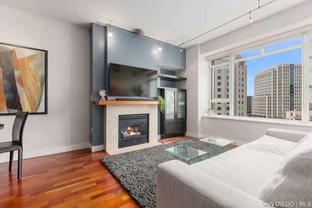 a living room with furniture a flat screen tv and a fireplace