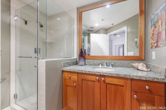 a bathroom with a granite countertop sink and a mirror