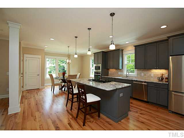 610 Chamberlain Street Raleigh, NC 27607 - Photo 4 of 25 The heart of the home, open to the breakfast area and living room. Custom cabinets, high end granite and appliances, tumbled brick backsplash.