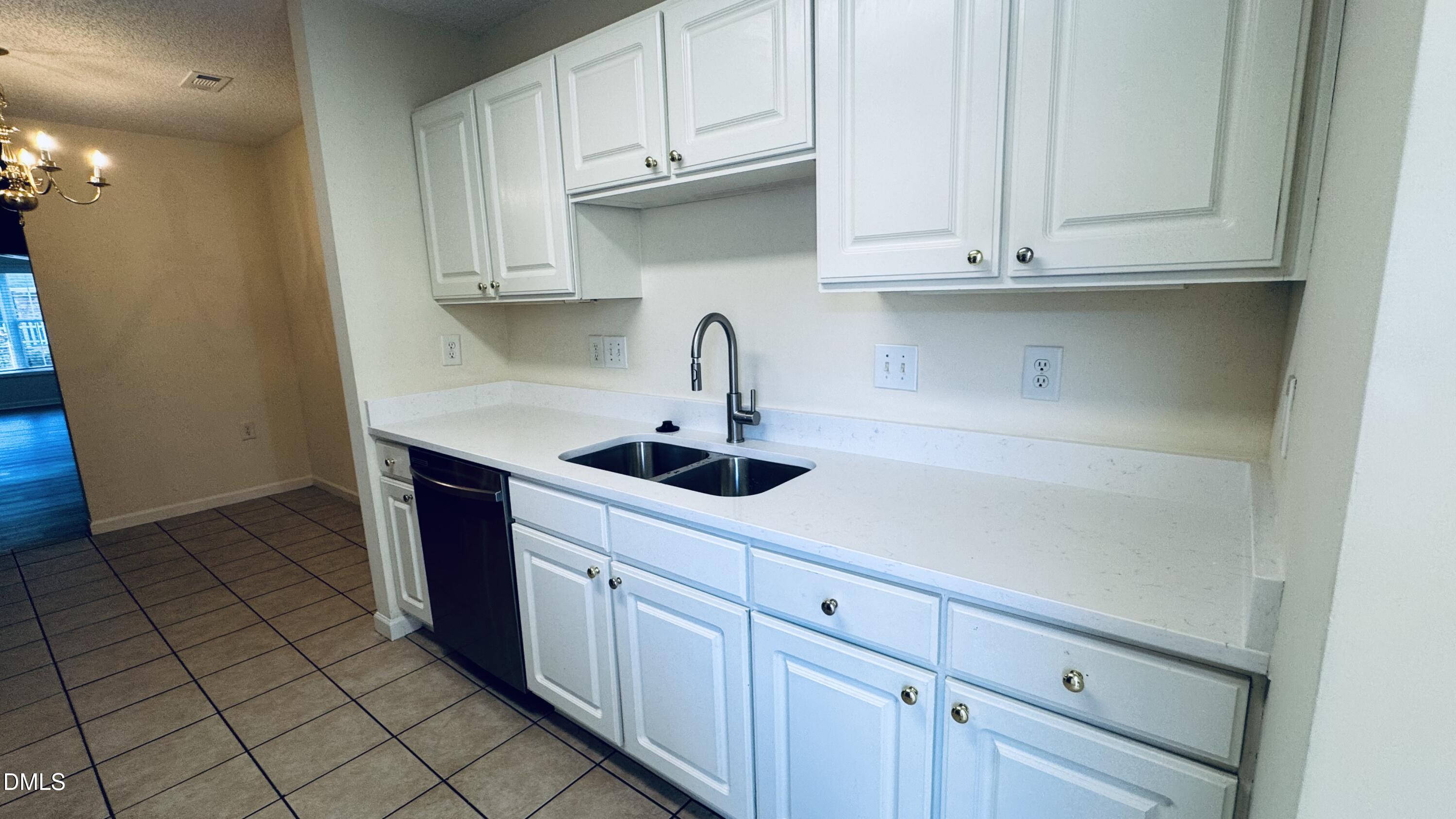 11320 Clubhaven Place, Unit 103 Raleigh, NC 27617 - Photo 6 of 13 a kitchen with stainless steel appliances granite countertop a sink and dishwasher with white cabinets