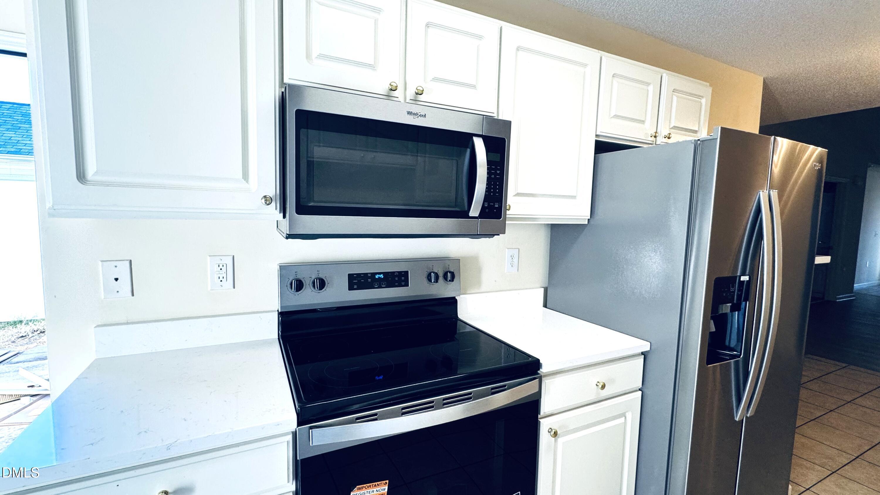 11320 Clubhaven Place, Unit 103 Raleigh, NC 27617 - Photo 7 of 13 a kitchen with stainless steel appliances a stove microwave and refrigerator