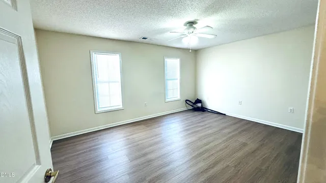 an empty room with wooden floor and window