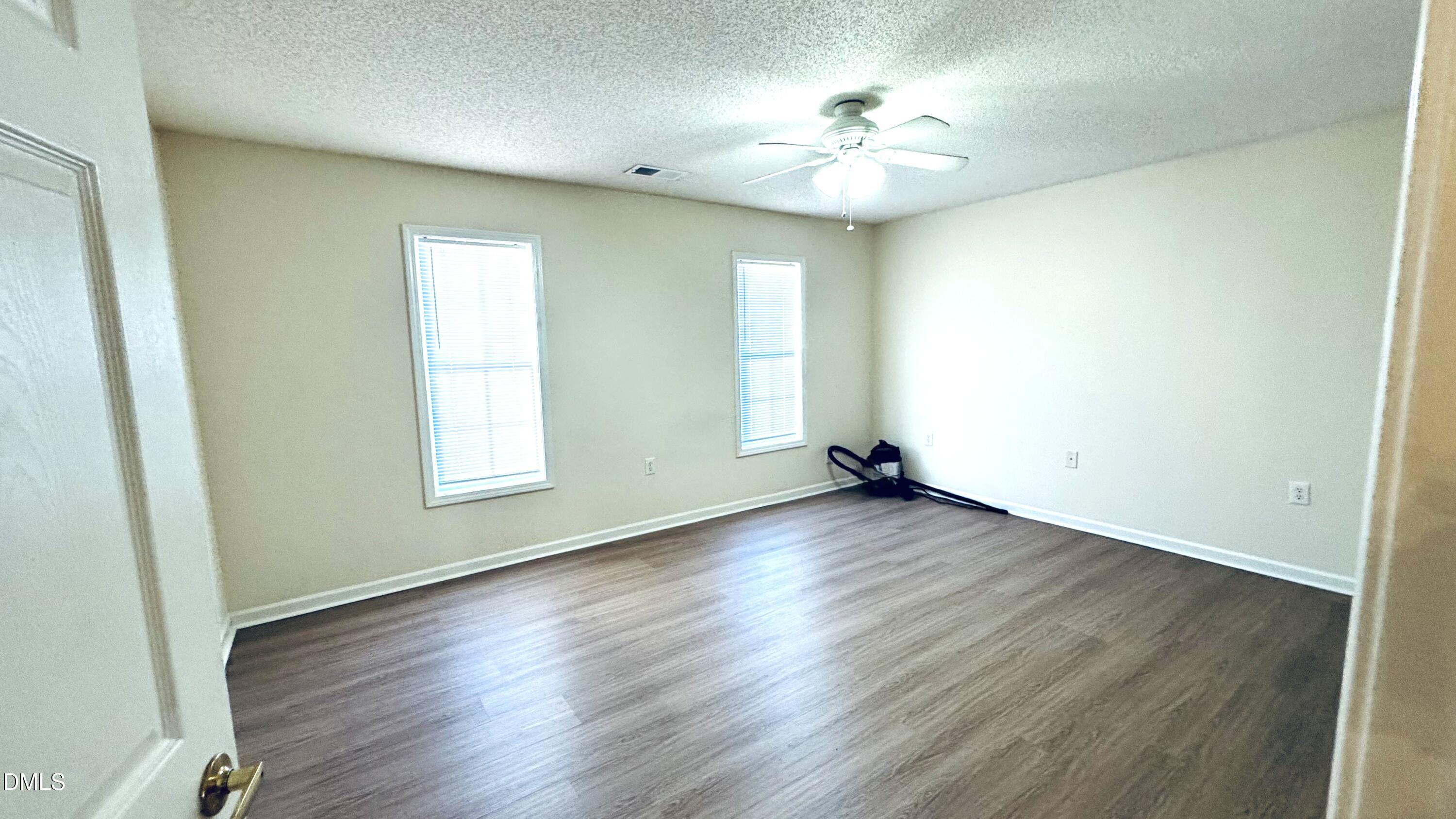 11320 Clubhaven Place, Unit 103 Raleigh, NC 27617 - Photo 8 of 13 an empty room with wooden floor and window