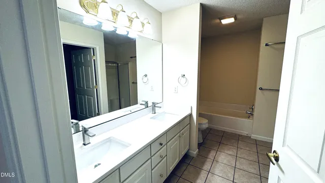 a bathroom with a double vanity sink a toilet and a mirror