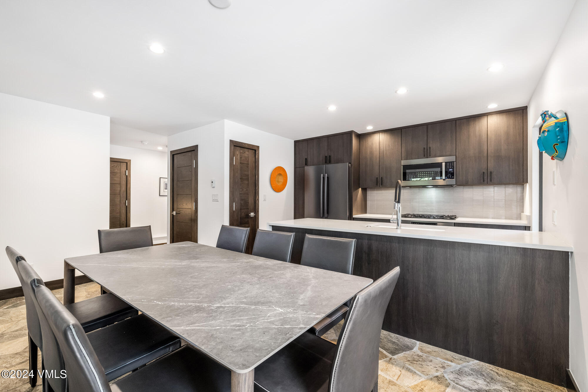 3891 Big Horn Road, Unit C Vail, CO 81657 - Photo 11 of 53 a kitchen with granite countertop a table chairs microwave and refrigerator