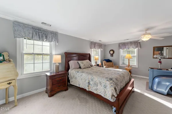 a bedroom with a bed and dresser with mirror