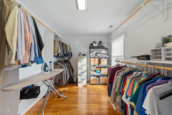 a view of walk in closet with clothes and shoes