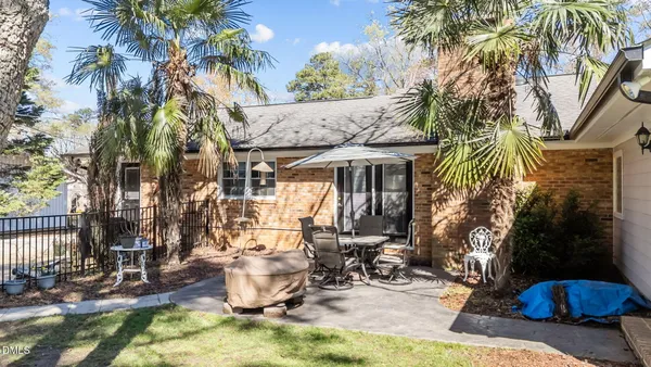 a view of a patio with a table and chairs under an umbrella