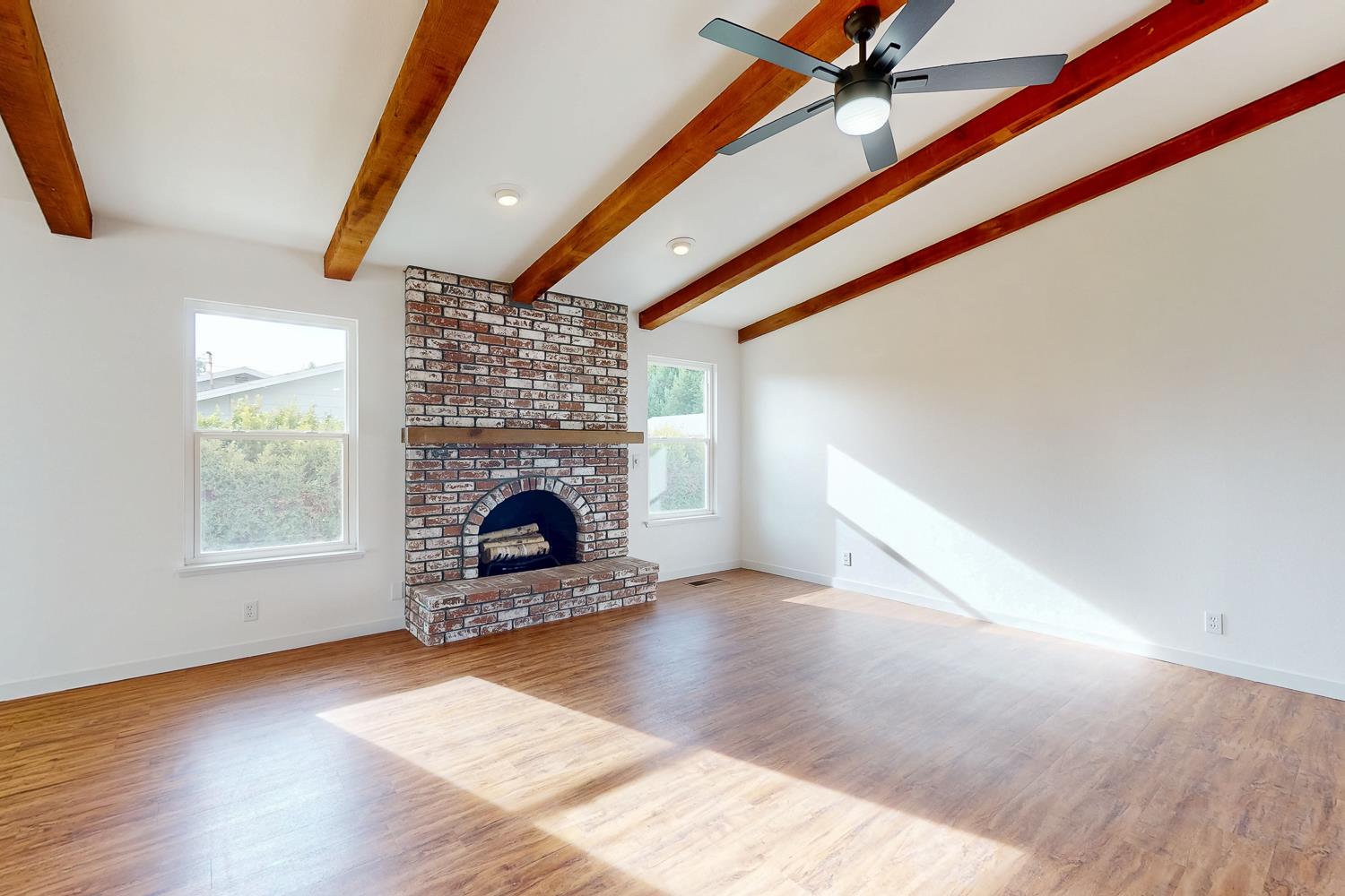 7830 Griffith Lane Sutter, CA 95982 - Photo 11 of 69 a view of an empty room with wooden floor fireplace and a window