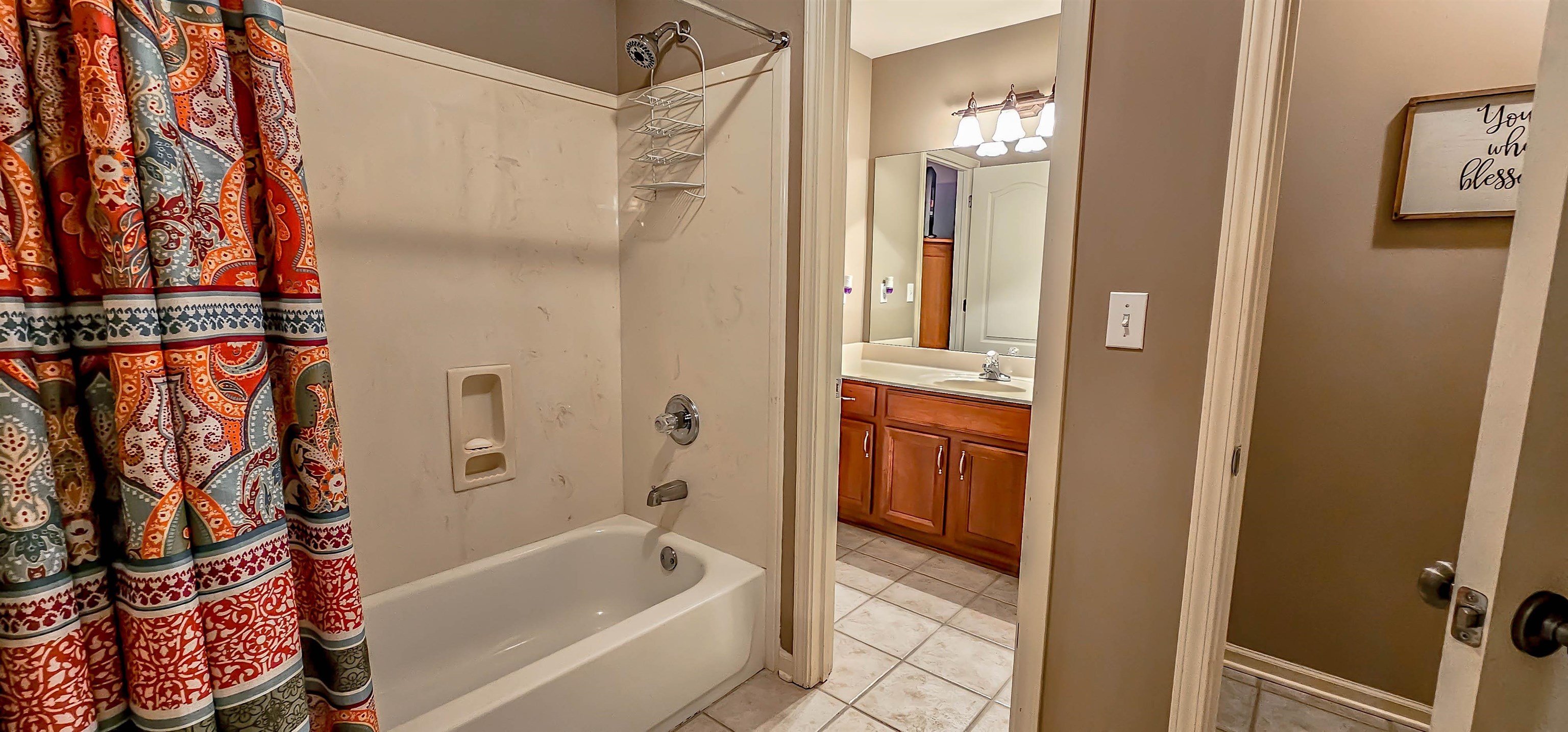 824 McFerrin Lane Collierville, TN 38017 - Photo 22 of 25 Bathroom with shower / bathtub combination with curtain, vanity, and light tile patterned floors