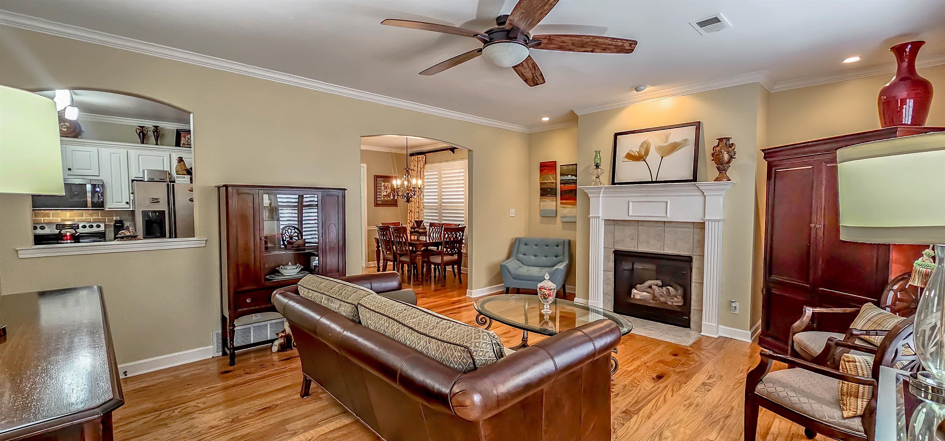 824 McFerrin Lane Collierville, TN 38017 - Photo 6 of 25 Living area featuring ceiling fan, light wood-style flooring, arched walkways, crown molding, and a fireplace