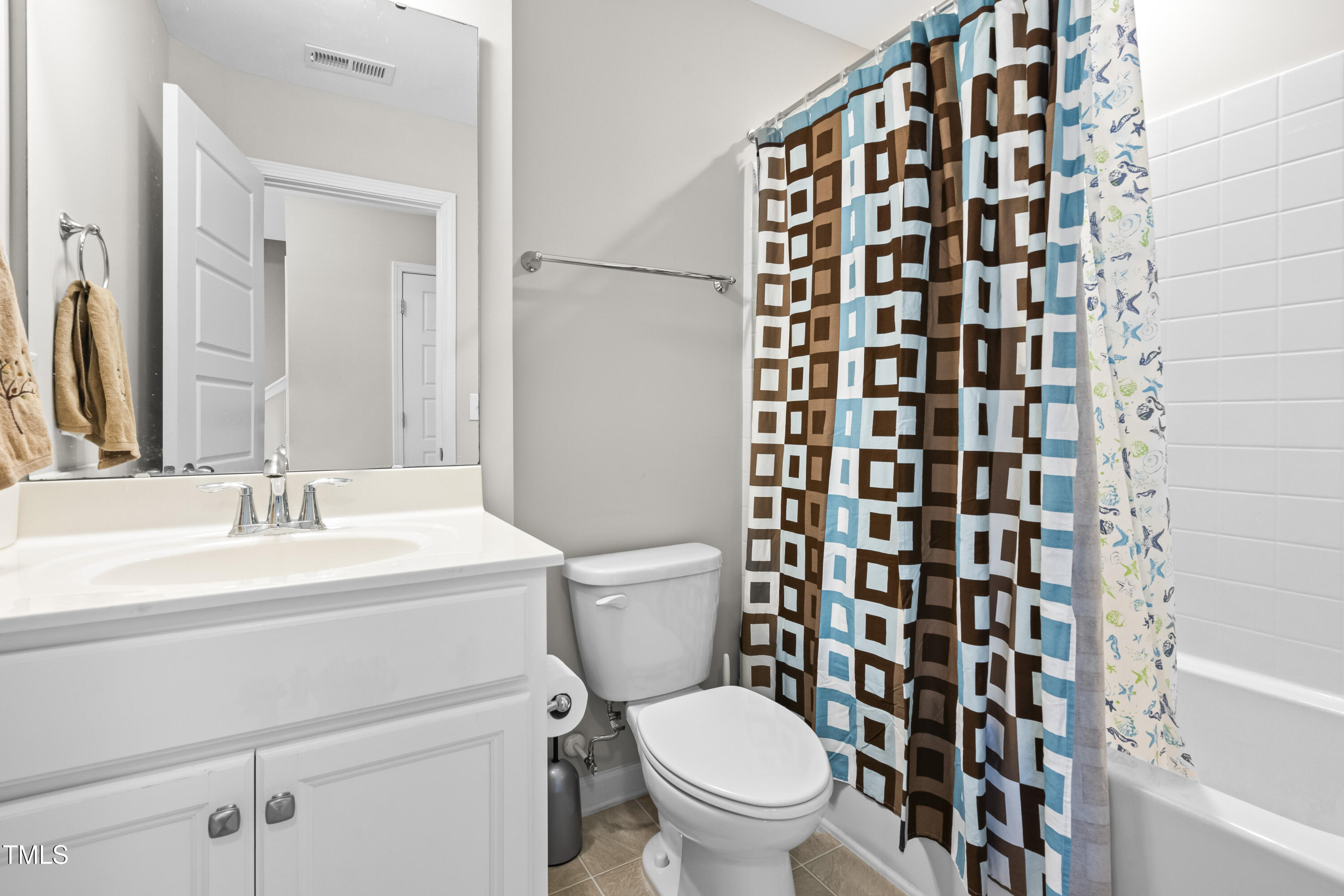 1004 Metropolitan Drive Durham, NC 27713 - Photo 16 of 28 a bathroom with a sink a toilet and shower curtain