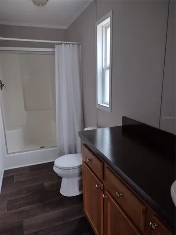 a bathroom with a granite countertop sink toilet and a mirror