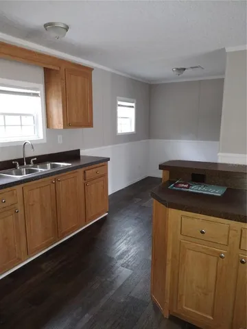 a kitchen with stainless steel appliances granite countertop a sink a stove a microwave cabinets and wooden floor