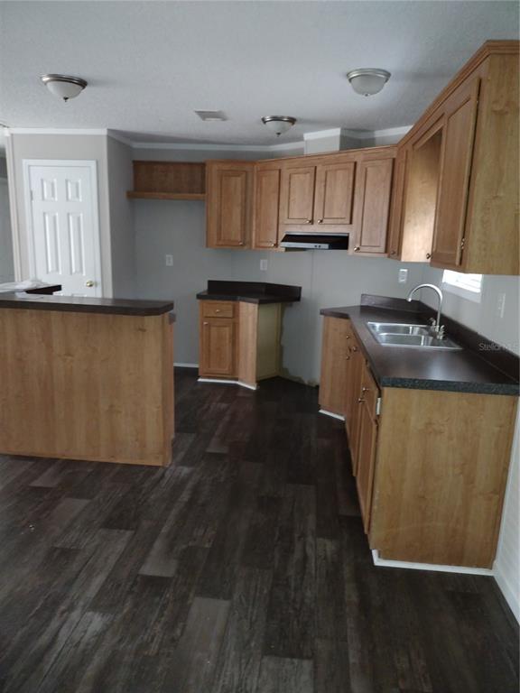 13144 Southwest 18th Street Road Ocala, FL 34481 - Photo 3 of 20 a kitchen with granite countertop a refrigerator a stove a sink and dishwasher with wooden floor