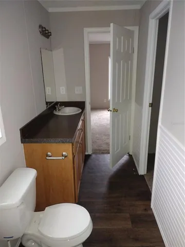 a bathroom with a granite countertop toilet sink and mirror