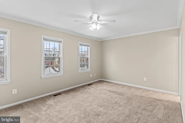 a view of an empty room and chandelier fan